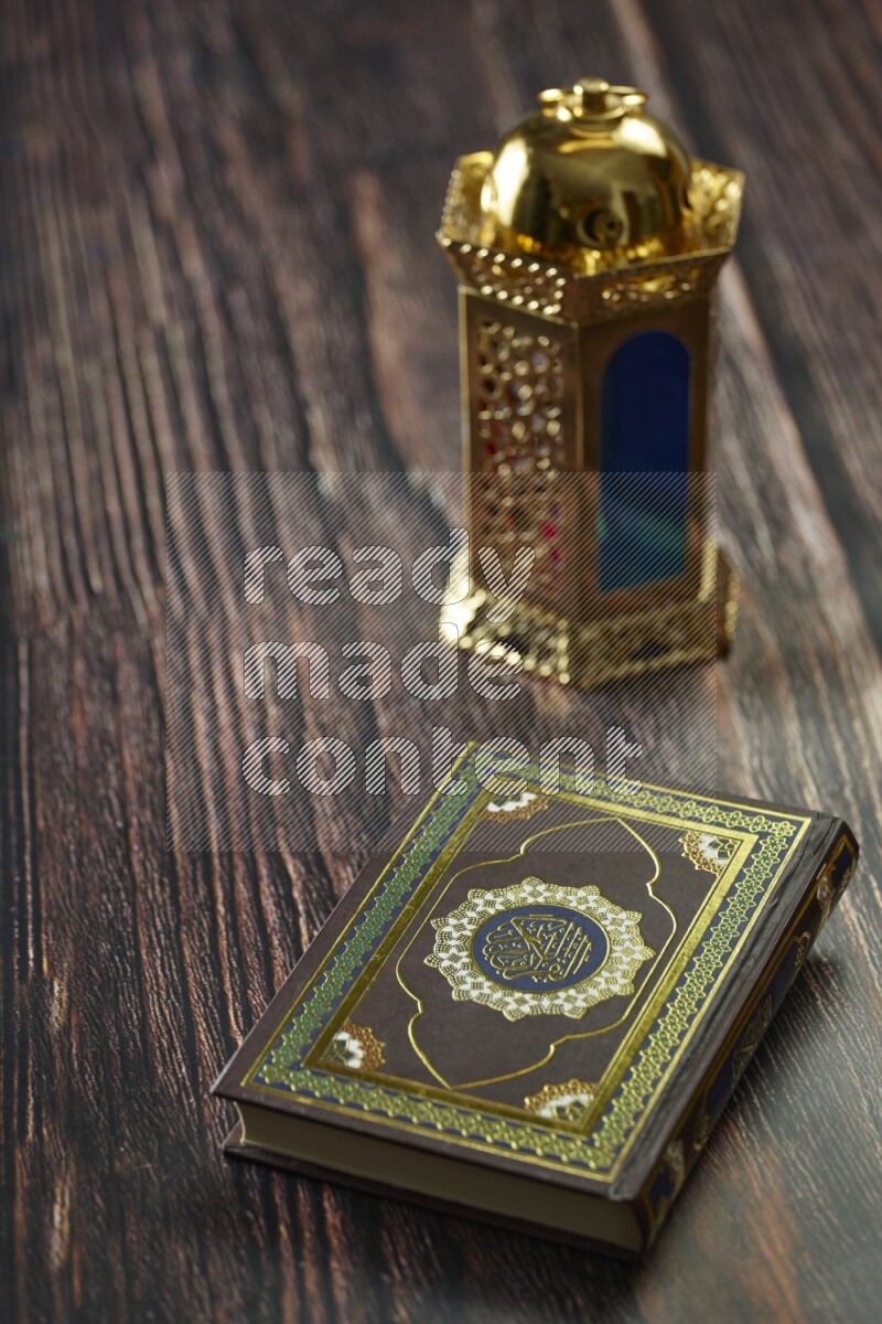 A golden lantern with different drinks, dates, nuts, prayer beads and quran on brown wooden background
