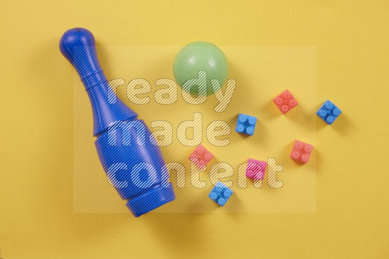 Plastic building blocks, balls and bowling pins on different colored backgrounds (kids toys)