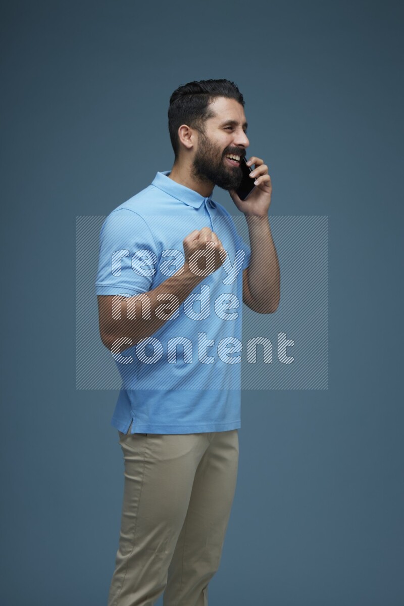 A man having a Call in a blue background wearing a Blue shirt