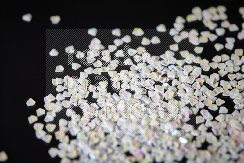 Colorful plastic shards for decoration scattered on a black background