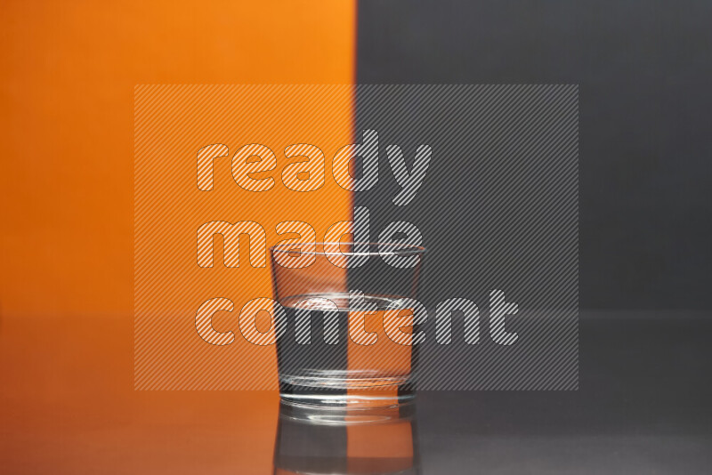 The image features a clear glassware filled with water, set against orange and black background