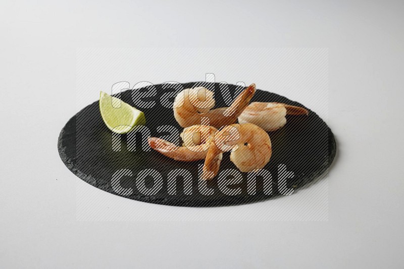 four grilled shrimp  on a black slate direct  on a white back ground