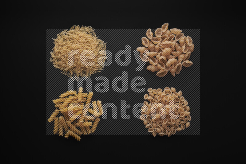 Different pasta types in bunches on black background