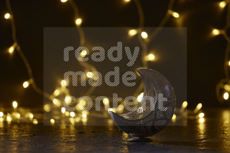 A traditional ramadan lantern surrounded by glowing fairy lights in a dark setup