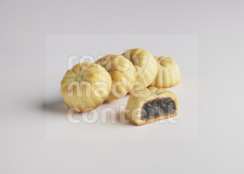 Five Pieces of Maamoul filled with date one of them is cut direct on white background