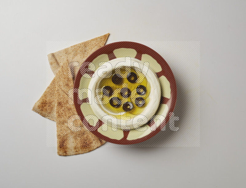 Lebnah garnished with sliced olives in a traditional plate on a white background