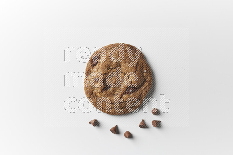 A single chocolate chips cookie with chocolate beside it on a white background