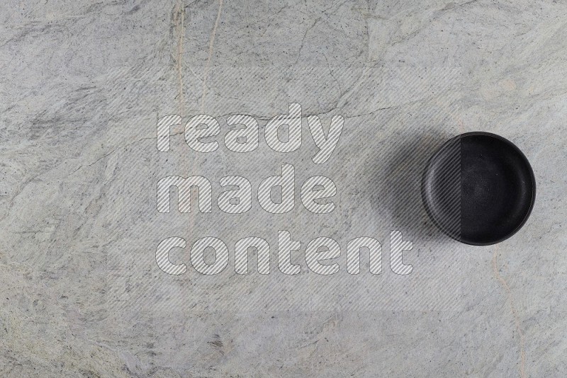 Top View Shot Of A Black Pottery Bowl On Grey Marble Flooring