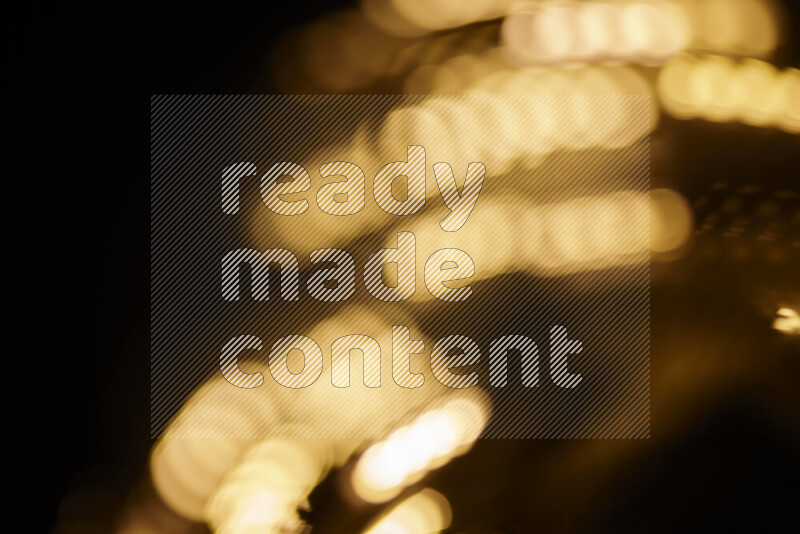 Light bulbs glowing against backdrop of golden bokeh