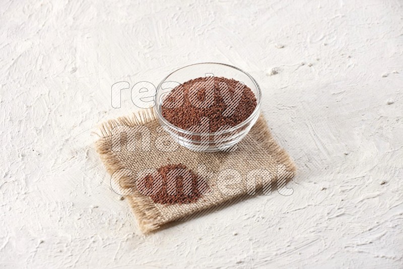 A glass bowl full of garden cress on a burlap fabric on textured white flooring in different angles