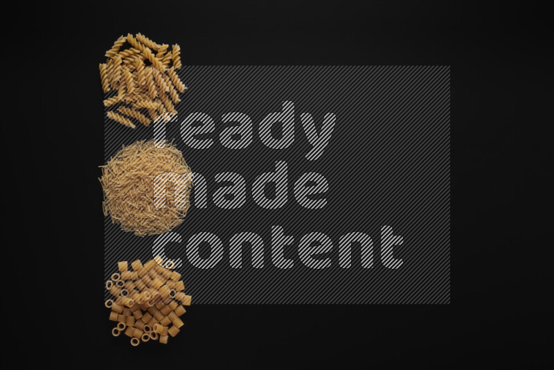 Different pasta types in 3 bunches on black background