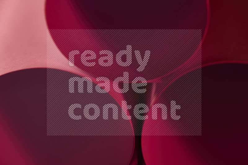 الصورة تعرض فن ورقي تجريدي بأشكال دائرية بدرجات متنوعة من اللون الأحمر