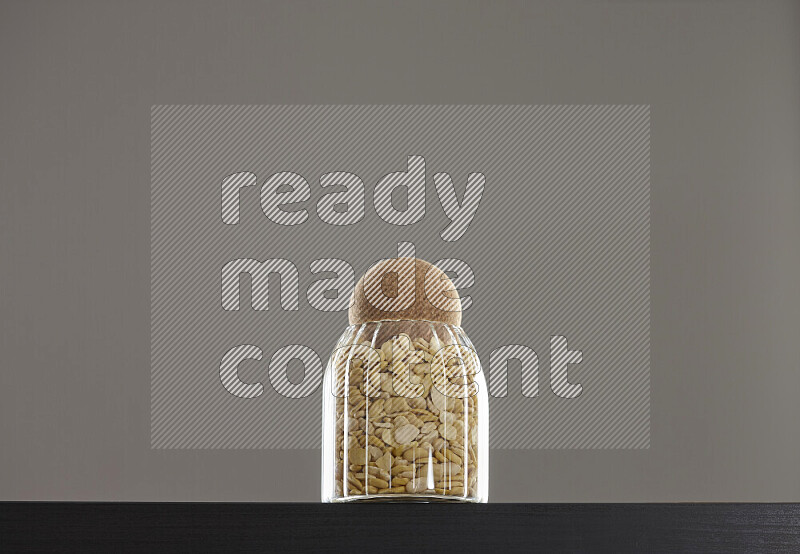 Crushed beans in a glass jar on black background