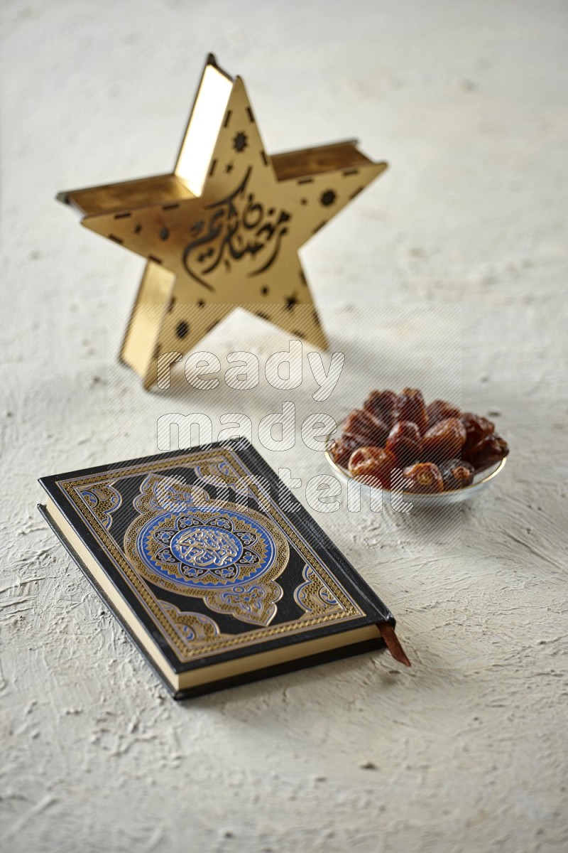 A wooden golden star lantern with different drinks, dates, nuts, prayer beads and quran on textured white background