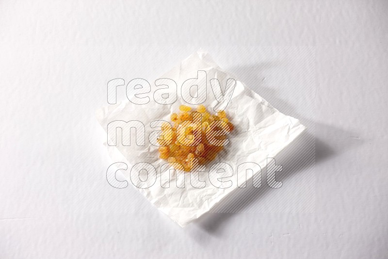 Raisins on a crumpled piece of paper on a white background in different angles