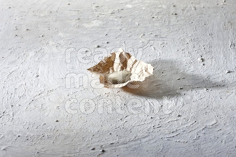 بودرة الفلفل الأبيض في قطعة من الورق على أرضية بيضاء