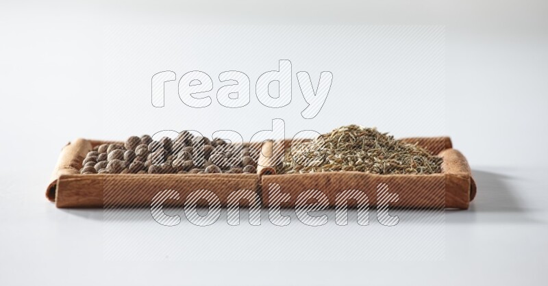 2 squares of cinnamon sticks full of allspice and cumin on white flooring