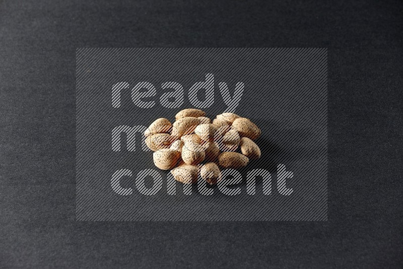 A bunch of almonds on a black background in different angles