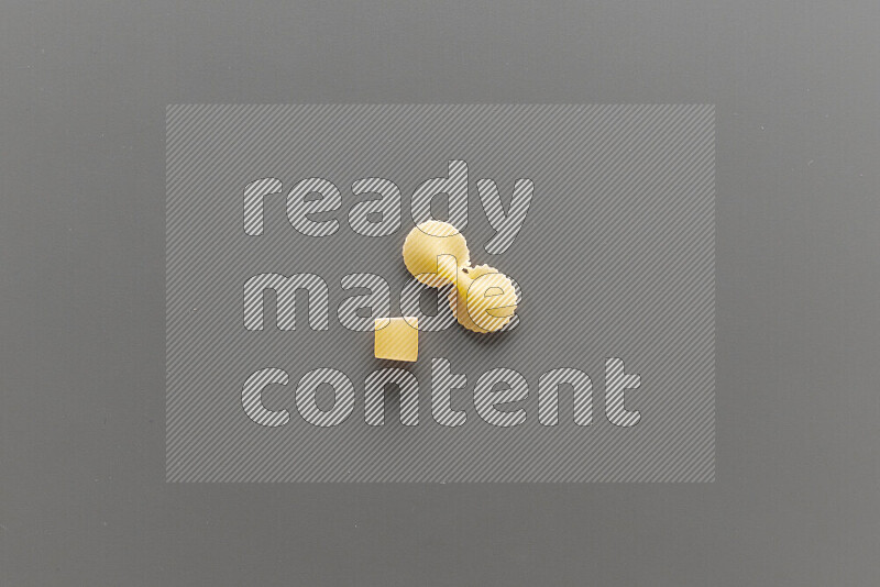 Big rings pasta with other types of pasta on grey background