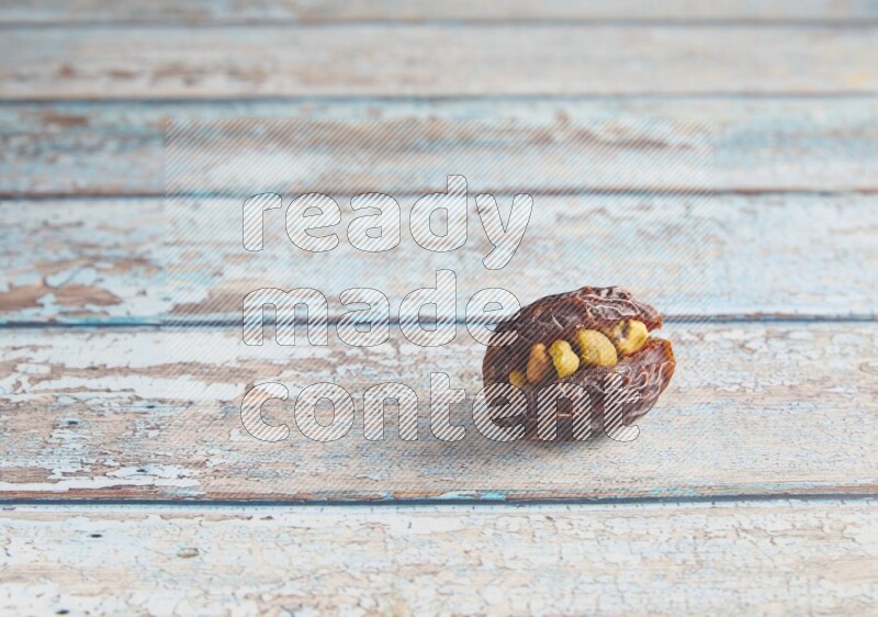 pistachio stuffed madjoul date on a light blue wooden background