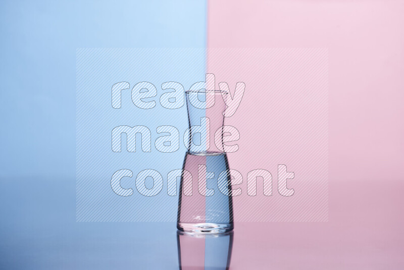 The image features a clear glassware filled with water, set against light blue and rose background