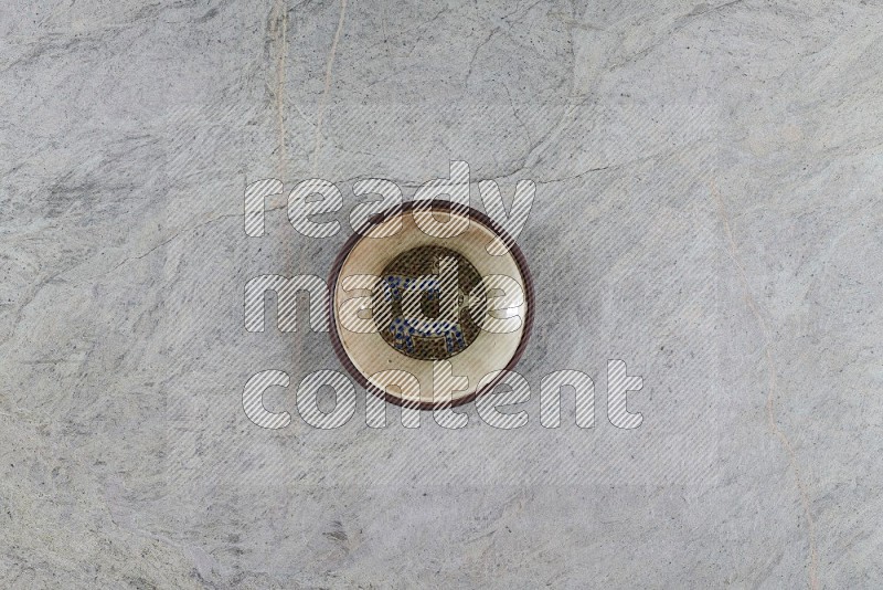 Top View Shot Of A Decorative Pottery Plate On Grey Marble Flooring