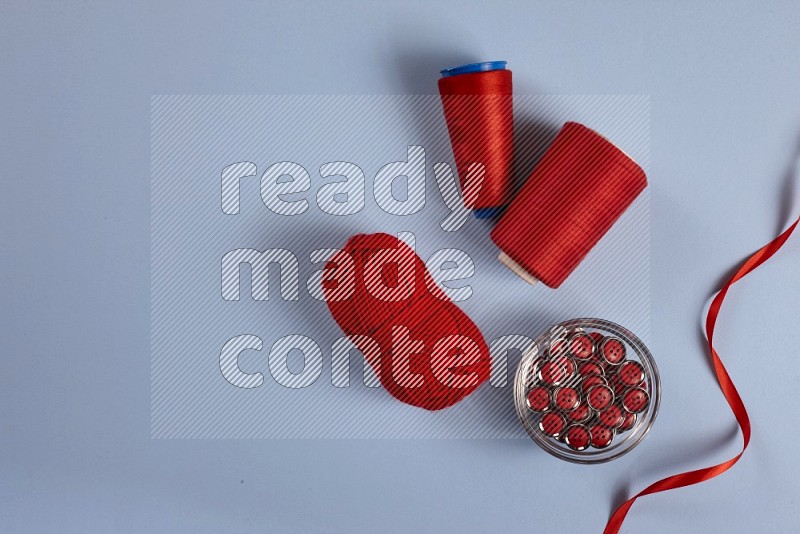 Red sewing supplies on blue background