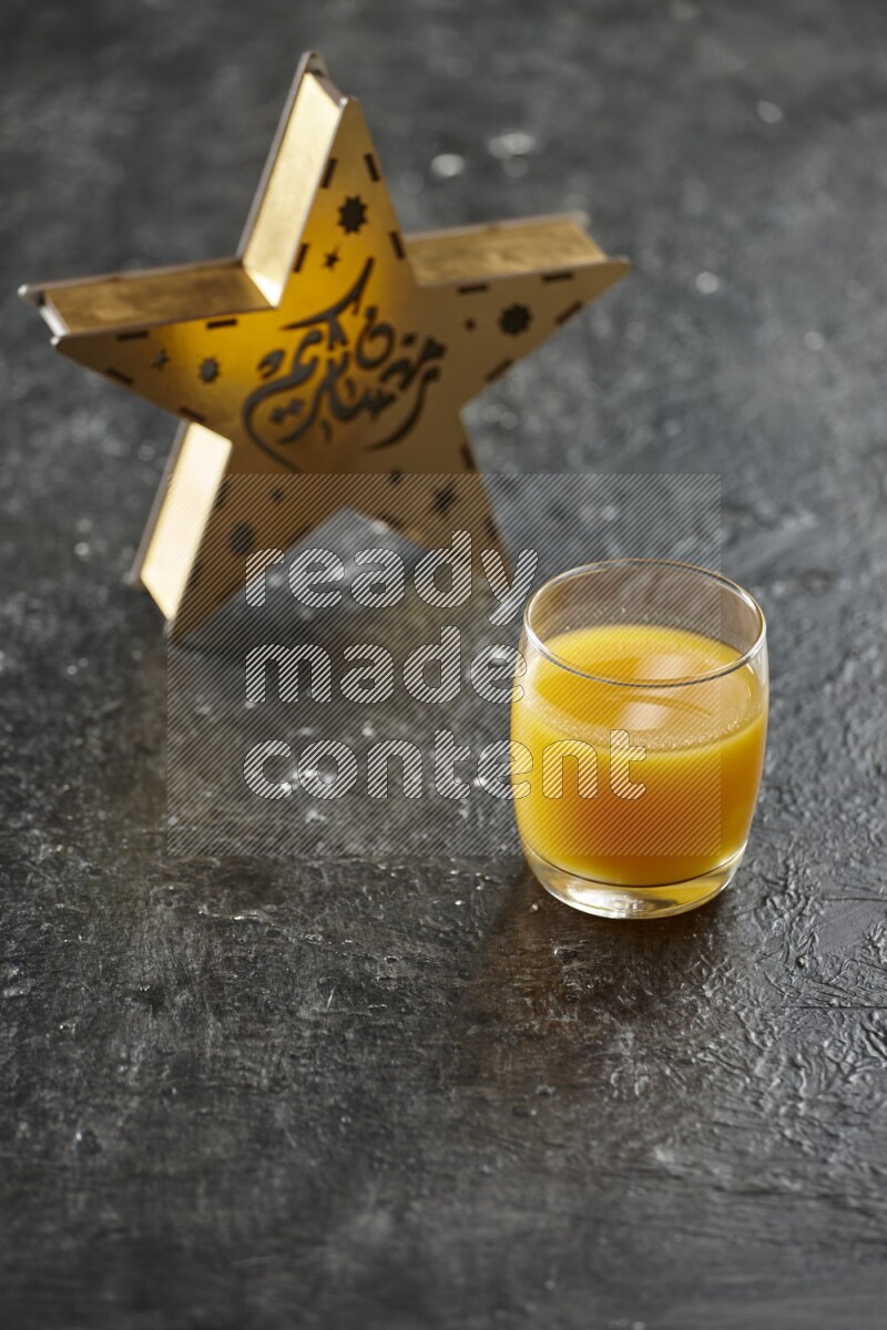 A wooden golden star lantern with different drinks, dates, nuts, prayer beads and quran on textured black background