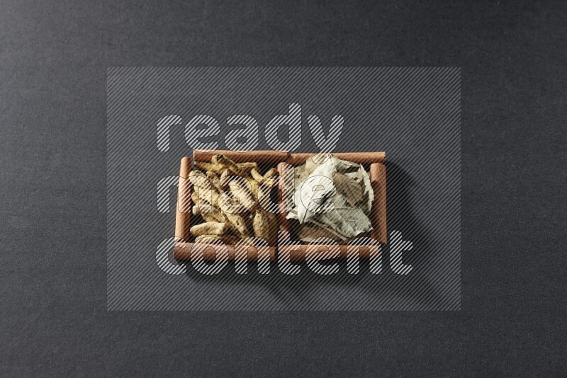 2 squares of cinnamon sticks full of bay laurel leaves and turmeric fingers on black flooring