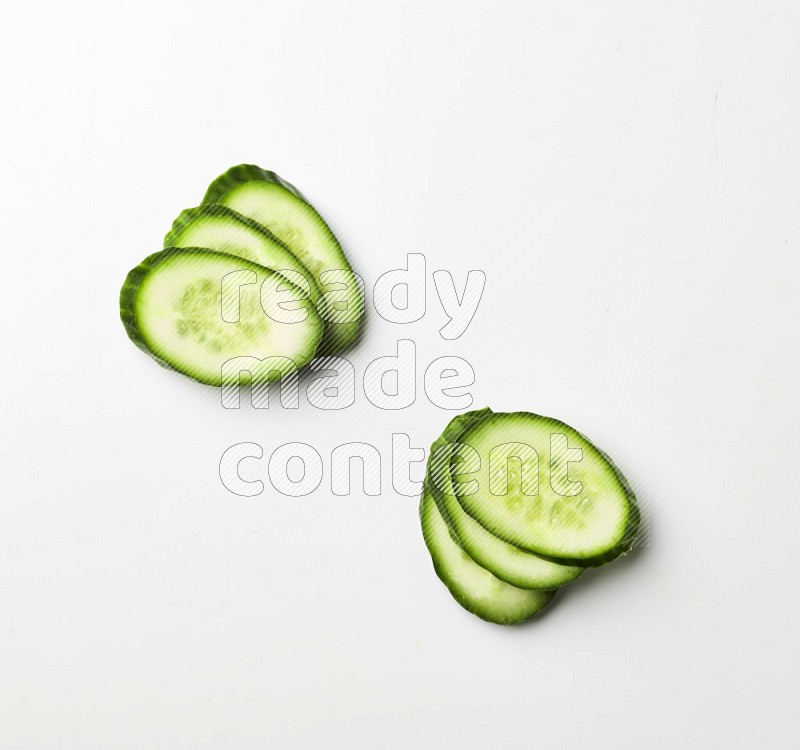 Multiple cucumber slices on white background