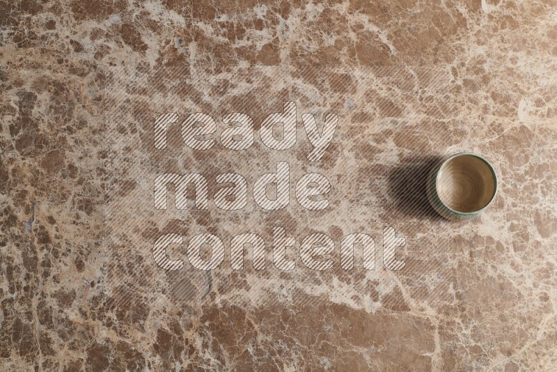 A multicolored pottery bowl on beige marble background