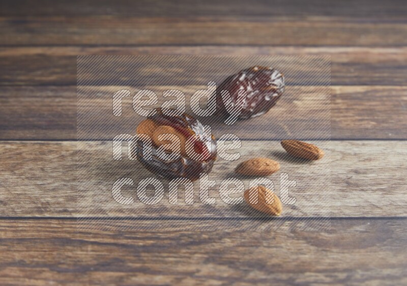 two almond stuffed madjoul dates on a wooden background