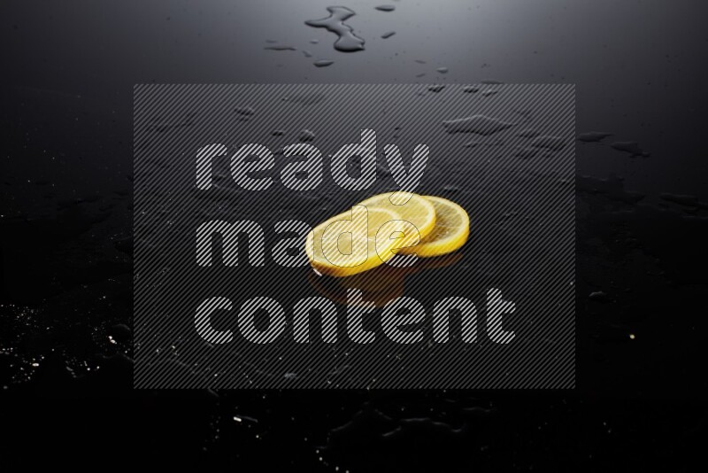 Lemon slices with water drops, and droplets on black background