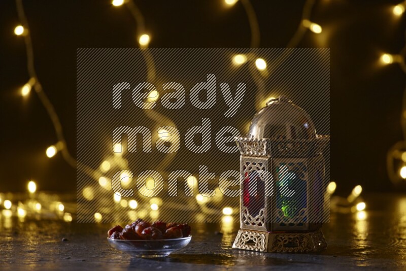 A traditional ramadan lantern surrounded by glowing fairy lights in a dark setup