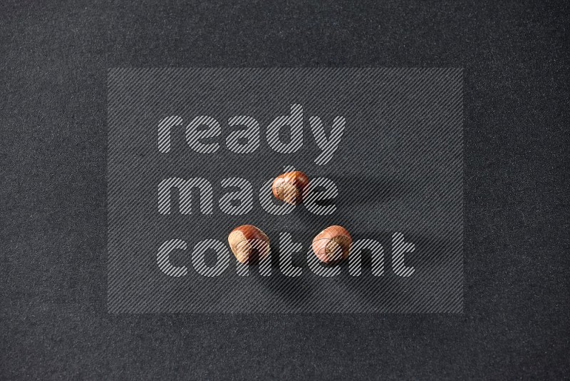 3 hazelnuts on a black background in different angles