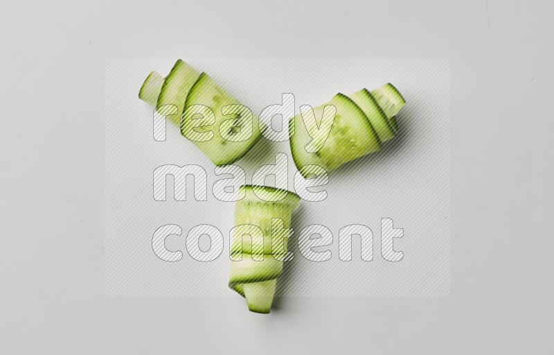 Three cucumber ribbons on a white background