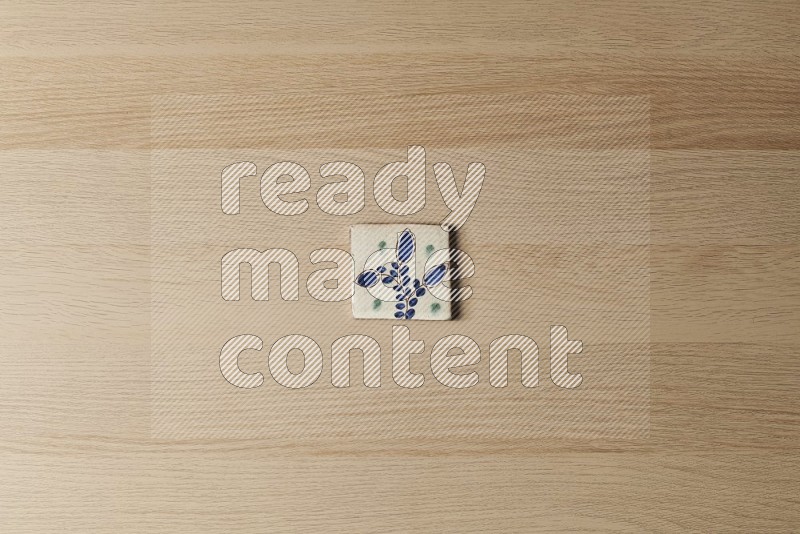 Top view shot of a pottery coaster\ tile on oak wooden flooring