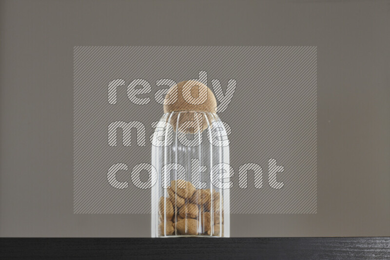 Almonds in a glass jar on black background