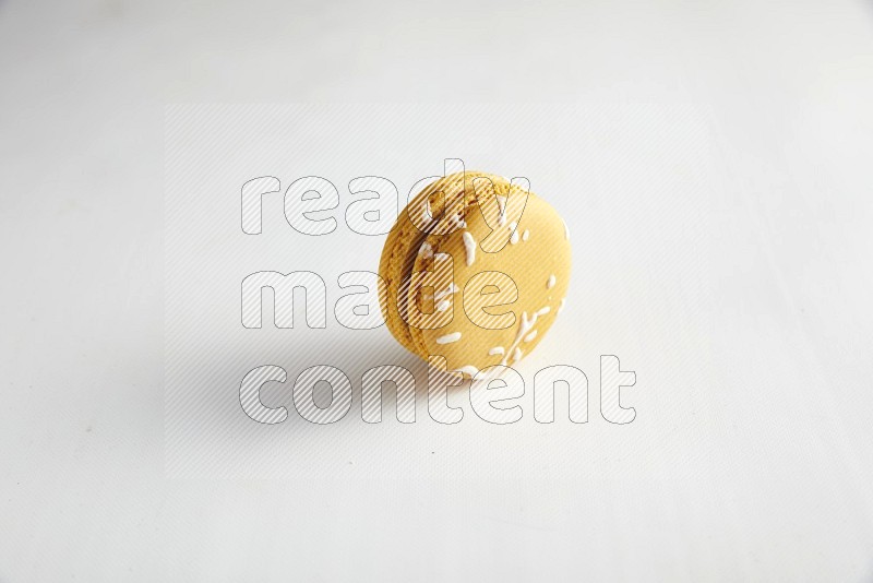 45º Shot of Yellow Piña Colada macaron on white background