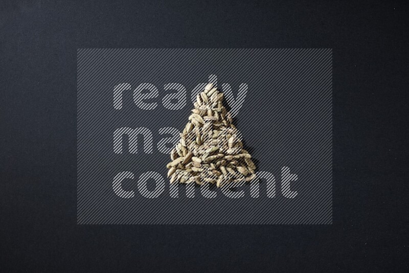 Cardamom in a triangle shape on black flooring