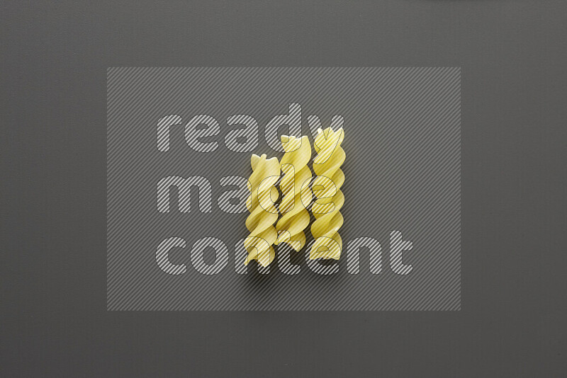 Fusilli pasta on grey background