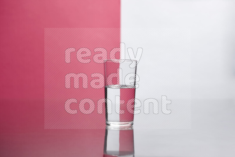 The image features a clear glassware filled with water, set against white and pink background