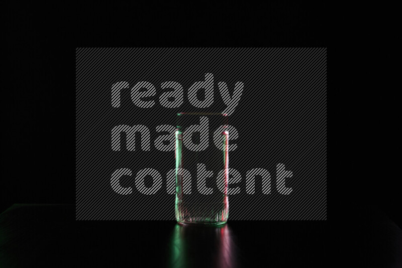 Glassware with rim light in red and green against black background