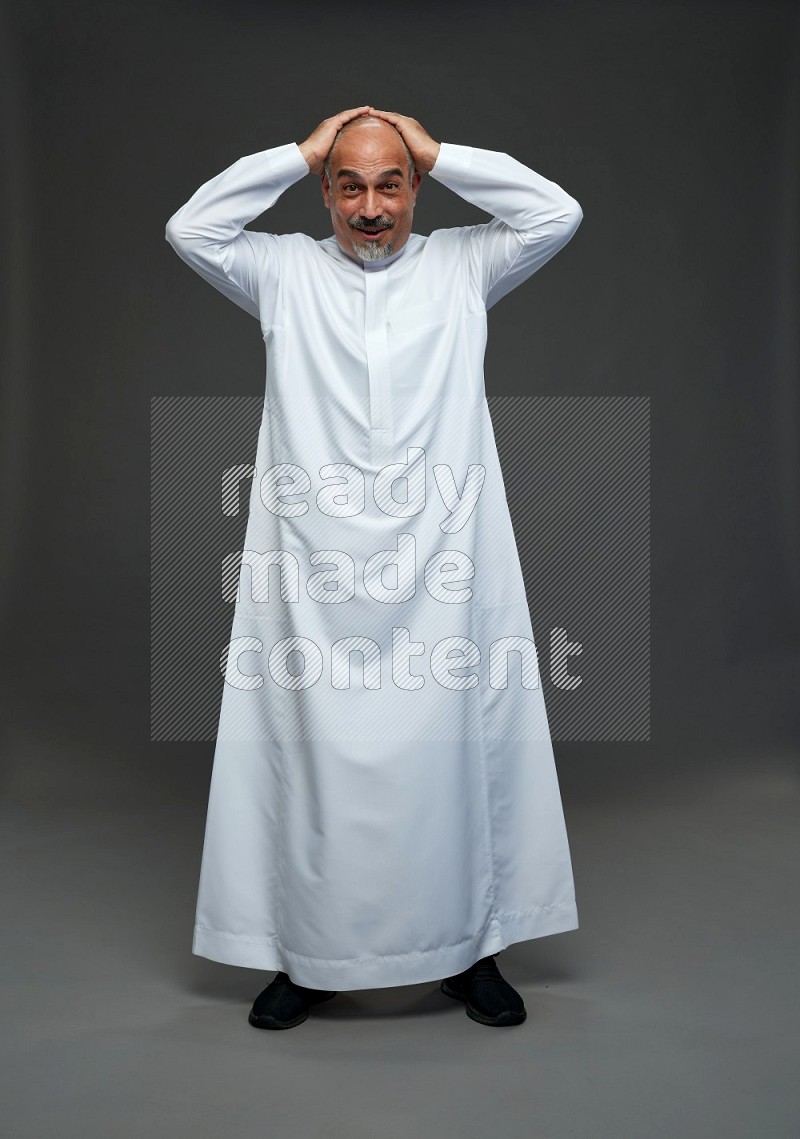 Saudi man without shomag Standing Interacting with the camera on gray background