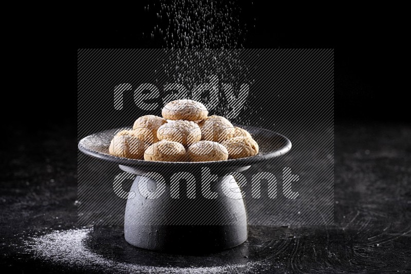 Kahk on a serving plate on a black background