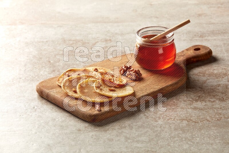 Five stacked dried orange mini pancakes on a wooden board on beige background