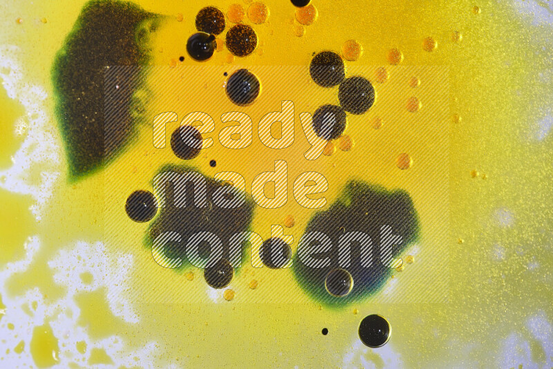 لقطات مقربة لقطرات ألوان مائية صفراء وزرقاء وخضراء على سطح الزيت على خلفية بيضاء