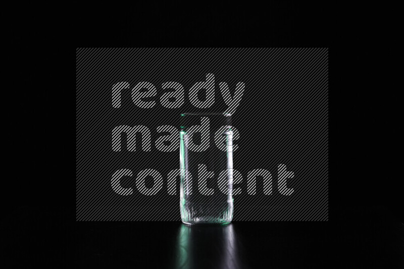 Glassware with rim light in green and white against black background