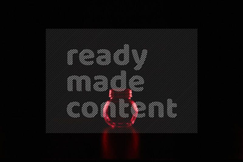 Glassware with rim light in red against black background