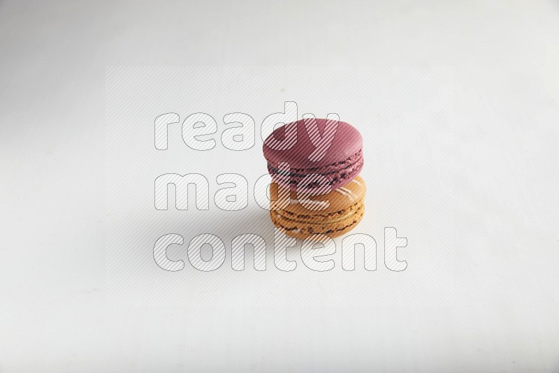 45º Shot of of two assorted Brown Irish Cream, and Red Cherry macarons on white background